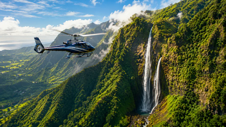 A private helicopter flying past a tall Hawaiian waterfall